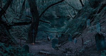 Movie still from “The Field Guide to Evil” (2018), directed by Can Evrenol – A man walking through the woods; Extreme Wide shot, High angle