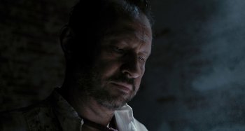 Movie still from “The Field Guide to Evil” (2018), directed by Can Evrenol – A person wearing a white shirt; Close Up shot, Low angle