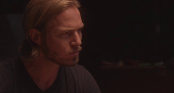 Movie still from “The Field Guide to Evil” (2018), directed by Can Evrenol – A person with long hair and a beard; Close Up shot, Over the shoulder angle