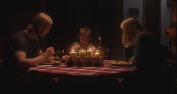Movie still from “The Field Guide to Evil” (2018), directed by Can Evrenol – Three people sitting around a table with candles; Medium shot, High angle