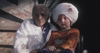 Movie still from “The Field Guide to Evil” (2018), directed by Can Evrenol – An old man and a young boy with bandages on their heads; Medium shot, High angle