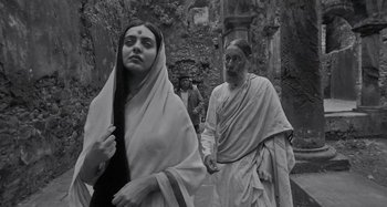 Movie still from “The Field Guide to Evil” (2018), directed by Can Evrenol – A man and a woman walking down a street; Medium shot, Low angle