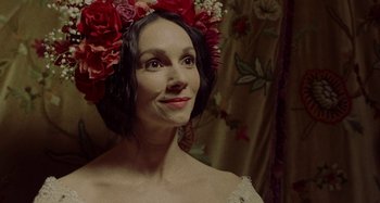Movie still from “The Field Guide to Evil” (2018), directed by Can Evrenol – A woman wearing a flower crown and a white dress; Close Up shot, Over the shoulder angle