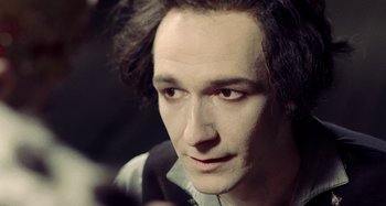 Movie still from “The Field Guide to Evil” (2018), directed by Can Evrenol – A person wearing a black shirt; Close Up shot, Over the shoulder angle