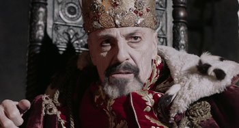 Movie still from “The Field Guide to Evil” (2018), directed by Can Evrenol – A person with a beard wearing a crown; Close Up shot, Low angle