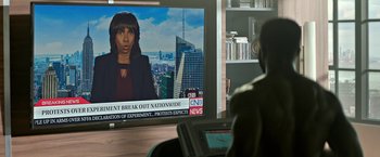 Movie still from “The First Purge” (2018), directed by Gerard McMurray – A person sitting in front of a television; Medium shot, High angle