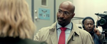 Movie still from “The First Purge” (2018), directed by Gerard McMurray – A man in a suit and red neck tie; Close Up shot, Over the shoulder angle