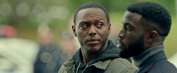 Movie still from “The First Purge” (2018), directed by Gerard McMurray – A person wearing a jacket; Close Up shot, Over the shoulder angle