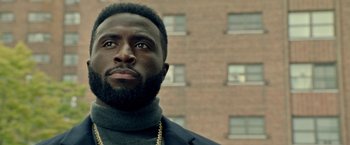 Movie still from “The First Purge” (2018), directed by Gerard McMurray – A person wearing a suit jacket; Close Up shot, Low angle