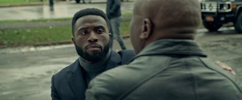 Movie still from “The First Purge” (2018), directed by Gerard McMurray – A man in a black jacket is looking at another man in a black jacket; Close Up shot, Over the shoulder angle