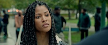 Movie still from “The First Purge” (2018), directed by Gerard McMurray – A person with long braids; Close Up shot, Over the shoulder angle