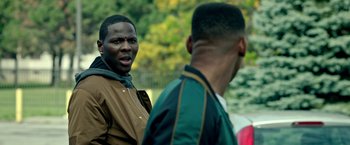 Movie still from “The First Purge” (2018), directed by Gerard McMurray – Two young men standing next to each other on a field; Close Up shot, Over the shoulder angle