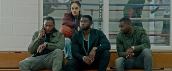 Movie still from “The First Purge” (2018), directed by Gerard McMurray – A group of men sitting next to each other on top of a bench; Medium shot, High angle