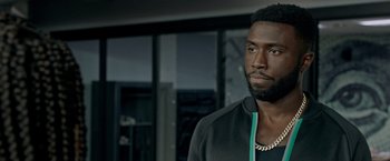 Movie still from “The First Purge” (2018), directed by Gerard McMurray – A person with a beard wearing a jacket; Close Up shot, Over the shoulder angle