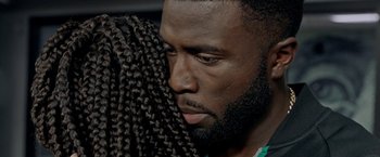 Movie still from “The First Purge” (2018), directed by Gerard McMurray – A person with long black hair; Extreme Close Up shot, Over the shoulder angle
