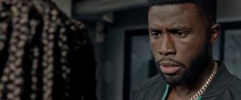 Movie still from “The First Purge” (2018), directed by Gerard McMurray – A person wearing a black shirt; Close Up shot, Over the shoulder angle