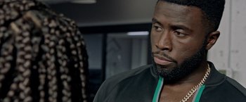 Movie still from “The First Purge” (2018), directed by Gerard McMurray – A person wearing a jacket; Close Up shot, Over the shoulder angle