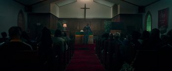 Movie still from “The First Purge” (2018), directed by Gerard McMurray – A man standing in front of a podium in a church; Wide shot, Low angle