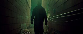 Movie still from “The First Purge” (2018), directed by Gerard McMurray – A man walking down a dark path in a building; Wide shot, Low angle