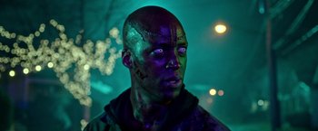 Movie still from “The First Purge” (2018), directed by Gerard McMurray – A man with blue and green makeup on his face; Close Up shot, Low angle