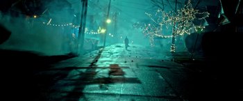 Movie still from “The First Purge” (2018), directed by Gerard McMurray – A person walking down a street at night with lights on; Extreme Wide shot, High angle