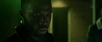 Movie still from “The First Purge” (2018), directed by Gerard McMurray – A man's face in a dark room; Close Up shot, Low angle