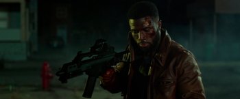Movie still from “The First Purge” (2018), directed by Gerard McMurray – A man in a leather jacket holding a gun; Medium shot, Low angle