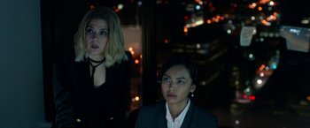 Movie still from “The First Purge” (2018), directed by Gerard McMurray – Two women in a dark room with lights in the background; Close Up shot, High angle