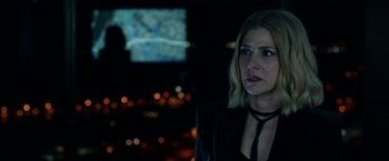 Movie still from “The First Purge” (2018), directed by Gerard McMurray – A woman standing in front of a television screen at night; Close Up shot, Over the shoulder angle