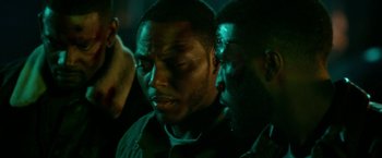 Movie still from “The First Purge” (2018), directed by Gerard McMurray – A man with his eyes closed and another man with his hand on his face; Close Up shot, Over the shoulder angle