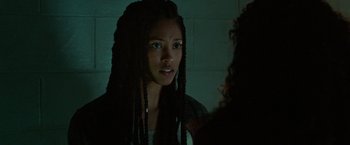 Movie still from “The First Purge” (2018), directed by Gerard McMurray – A young woman with long braids looking into a mirror; Close Up shot, Over the shoulder angle