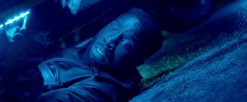 Movie still from “The First Purge” (2018), directed by Gerard McMurray – A person laying on the ground in the dark; Close Up shot, Overhead angle