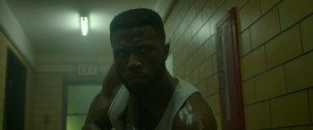 Movie still from “The First Purge” (2018), directed by Gerard McMurray – A person with his hand on his shoulder; Close Up shot, Low angle