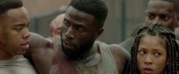 Movie still from “The First Purge” (2018), directed by Gerard McMurray – A person with blood on his face; Close Up shot, Over the shoulder angle