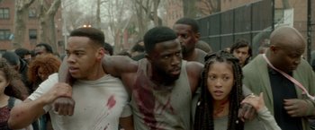 Movie still from “The First Purge” (2018), directed by Gerard McMurray – A group of young people walking down a street; Medium shot, Over the shoulder angle