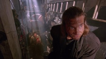 Movie still from “The Fisher King” (1991), directed by Terry Gilliam – A man in a dark room holding a cell phone in his hand; Medium shot, Low angle