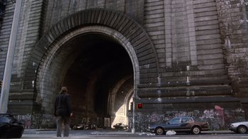 Movie still from “The Fisher King” (1991), directed by Terry Gilliam – A person standing in front of a tunnel with graffiti on it; Extreme Wide shot, Low angle