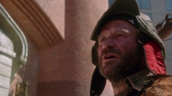 Movie still from “The Fisher King” (1991), directed by Terry Gilliam – A man with a beard wearing a helmet; Close Up shot, Low angle
