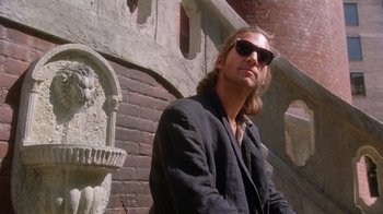 Movie still from “The Fisher King” (1991), directed by Terry Gilliam – A man in a black jacket and sunglasses; Medium shot, Low angle