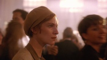 Movie still from “The Fisher King” (1991), directed by Terry Gilliam – A woman wearing a tan hat looking to her left; Close Up shot, Over the shoulder angle