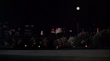 Movie still from “The Fisher King” (1991), directed by Terry Gilliam – A view of a city at night with a full moon in the background; Extreme Wide shot, High angle