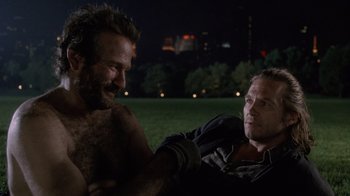 Movie still from “The Fisher King” (1991), directed by Terry Gilliam – Two men sitting in a field at night; Close Up shot, Over the shoulder angle