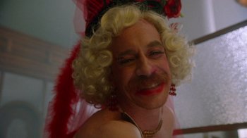 Movie still from “The Fisher King” (1991), directed by Terry Gilliam – A man with blonde curly hair wearing a red hat; Extreme Close Up shot, High angle