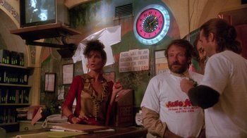 Movie still from “The Fisher King” (1991), directed by Terry Gilliam – A man and a woman standing in front of a counter; Medium shot, Low angle