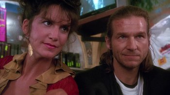 Movie still from “The Fisher King” (1991), directed by Terry Gilliam – A man and a woman sitting next to each other in front of a television; Close Up shot, Low angle