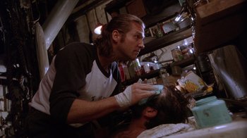 Movie still from “The Fisher King” (1991), directed by Terry Gilliam – A man is cutting another mans hair in a barber shop; Close Up shot, Low angle