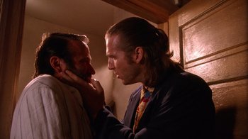 Movie still from “The Fisher King” (1991), directed by Terry Gilliam – A man with long hair is touching another man's face; Close Up shot, Over the shoulder angle