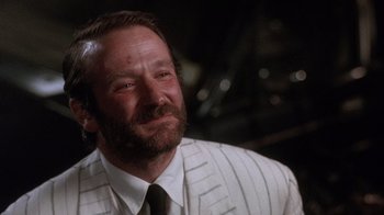 Movie still from “The Fisher King” (1991), directed by Terry Gilliam – A person wearing a suit and tie; Close Up shot, Over the shoulder angle