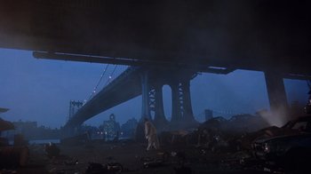 Movie still from “The Fisher King” (1991), directed by Terry Gilliam – A person standing under a bridge in the middle of the night; Extreme Wide shot, Low angle
