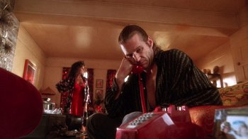 Movie still from “The Fisher King” (1991), directed by Terry Gilliam – A man sitting on the floor talking on the phone; Medium shot, Low angle